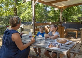 Camping Le Pech Charmant in de Dordogne, Frankrijk terras met gezin Camping Le Pech Charmant 30pluskids