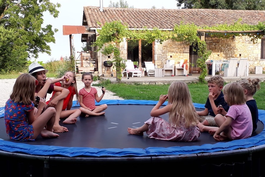 Kindjes op de trampoline met gite op achtergrond