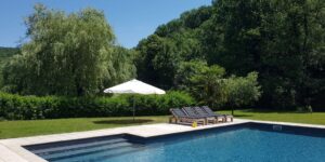 Heerlijk zwembad met ligbedden in groene omgeving