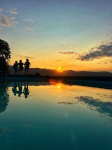 kinderen bij zwembad bij zonsondergang